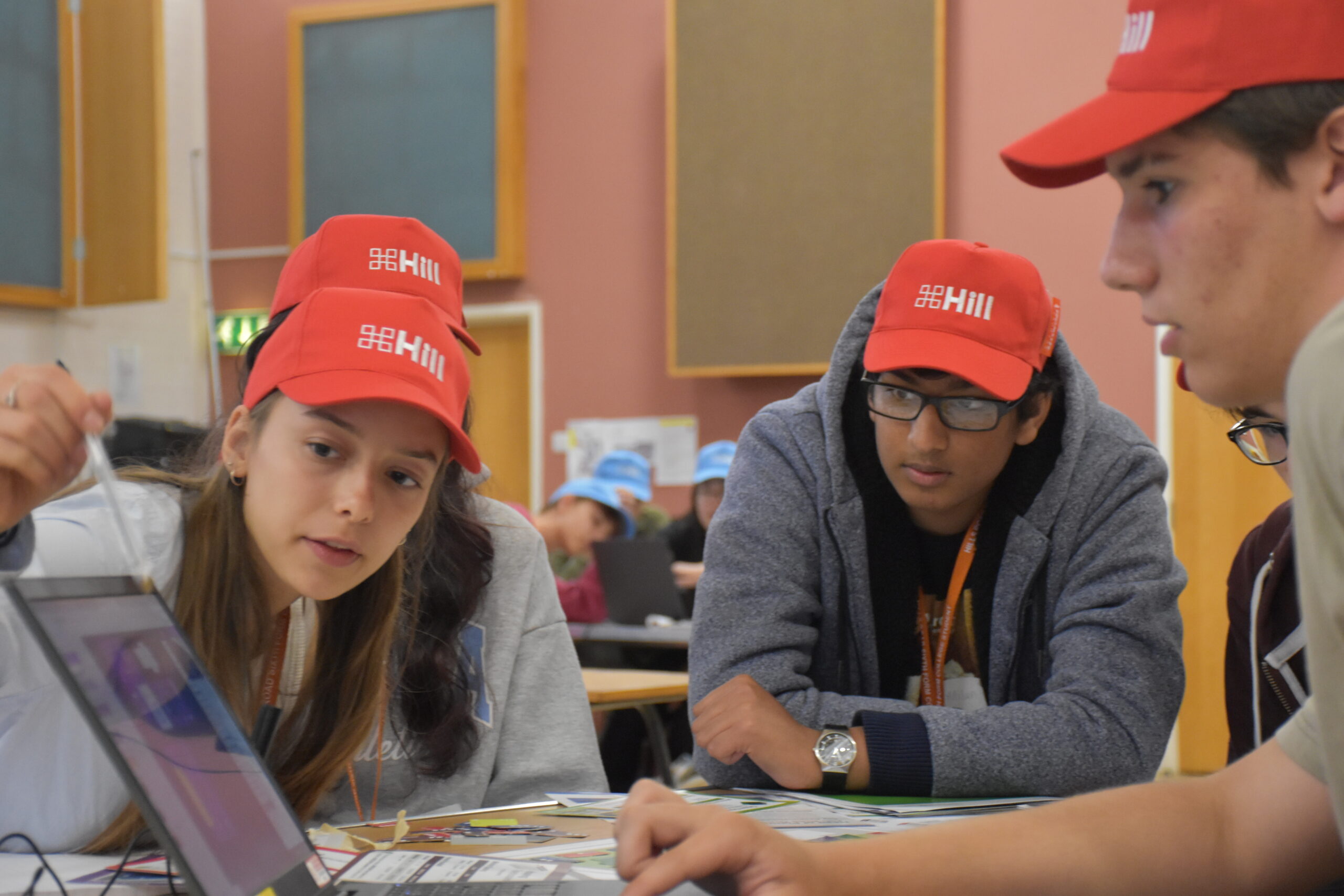 Students working together with red hats