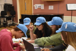 Students working together with blue hats